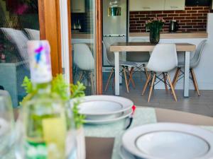 a table with white chairs and a table with at Dom nad jeziorem Miedwie, Zieleniewo in Zieleniewo