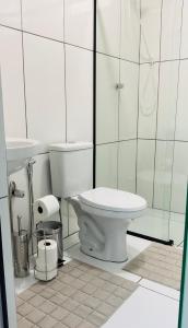 a white bathroom with a toilet and a sink at Suíte Privilegiada in Delfinópolis