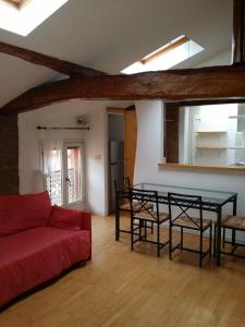 ein Wohnzimmer mit einem roten Sofa und einem Tisch in der Unterkunft Mansarda Santa Margherita in Bologna