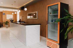 a bar with an orange and white counter at Via Brasil Hotel in São Luís