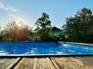 a swimming pool on a wooden table with the sun in the background at Le Pavillon, Grand Manoir du XVIIe avec Piscine, Bain Nordique et accès privé à la Charente in Alloué