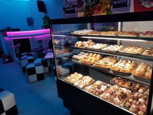 a display case filled with lots of different types of donuts at B&b Del Corso in Mandatoriccio +16 photos