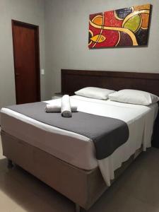 a bed in a bedroom with a painting on the wall at Abolição Praia Hotel in Fortaleza