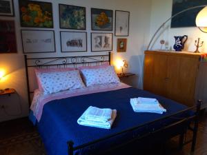 a bedroom with a blue bed with towels on it at Casa di Bruna in Poppi