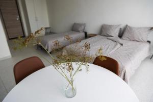 a bedroom with a bed and a table with a vase with flowers at ROOMS Park in Skuodas