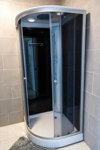 a glass shower in a shower stall in a bathroom at ROOMS Park in Skuodas