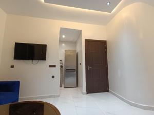 a room with a tv on the wall and a door at Appartement marhaba family only in Tangier