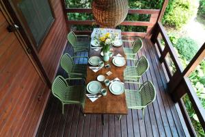 a wooden table and chairs on a deck at SikorQa Domek nad jeziorem in Skrzeszew