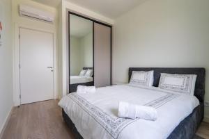 una camera da letto con un grande letto bianco con cuscini bianchi di Libera Luxe Residence a Belgrado
