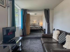 レインハムにあるNew! Cosy Garden Home, Free Parking With Smart TV & Perfect Motorway Accessのソファのあるリビングルームと寝室