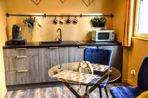 a kitchen with a table and a sink and a microwave at SPA & SAUNA lin pour l'autre in Calais