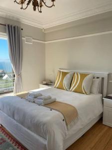 a bedroom with a large bed and a window at Little Penguin in Simonʼs Town