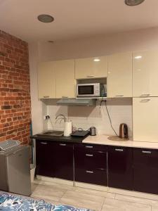 Una cocina con gabinetes blancos y un microondas. en Ceglany kąt, en Zielona Góra