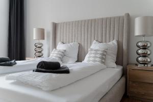 two beds with white sheets and pillows in a bedroom at Gemütliche & Individuelle Ferienwohnungen in Krefeld - JUNIK Apartments in Krefeld