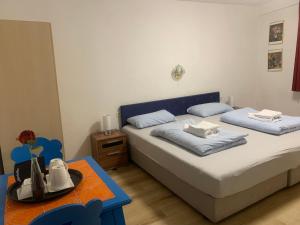 una piccola camera da letto con due letti e un tavolo di China Restaurant Hotel Lotus a Rothenburg ob der Tauber