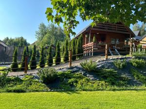 a log cabin with a fence and a yard at Domek na górce in Duszniki Zdrój