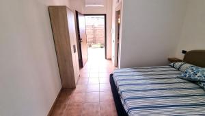 a bedroom with a bed and a hallway at CAMERETTA SUL MARE con OMBRELLONE in Lido Di Fondi