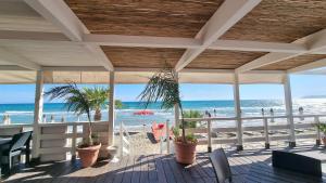 a porch with a view of the beach and the ocean at CAMERETTA SUL MARE con OMBRELLONE in Lido Di Fondi