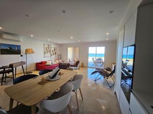a living room with a wooden table and chairs at Appartement Chez Emma, le luxe en Bord de Mer by Monarca in Saint-Florent