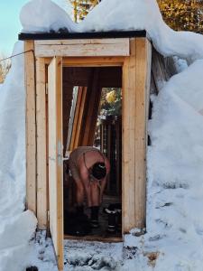 een persoon die voorovergebogen staat in een houten hondenhok bij Hotell Åre Fjällsätra in Undersåker +81 foto's