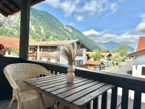 einen Holztisch auf einem Balkon mit einer Vase darauf in der Unterkunft Hotel garni Königslinde - Wandern, Radeln, Skifahren & Genießen in Bayrischzell