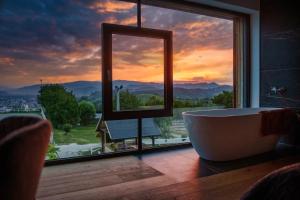 a bathroom with a tub and a window with a view at Hotel Frost in Maribor