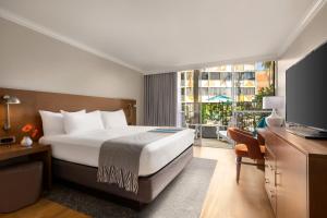 ein Hotelzimmer mit einem Bett und einem Fernseher in der Unterkunft Town and Country San Diego in San Diego