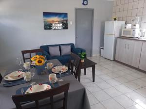 a living room with a table and a blue couch at Grateful Corner Apartment Curaçao in Willemstad +5 photos