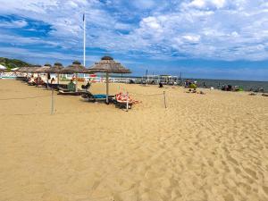 a group of people sitting on a beach with umbrellas at BaSoTo in Sopot