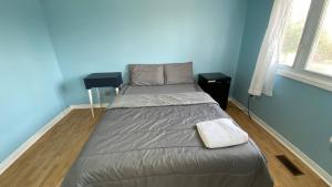 a bed in a room with a blue wall at Shelby in Mississauga