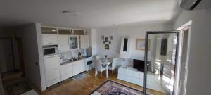 a kitchen with white cabinets and a table in it at Mima in Sarajevo