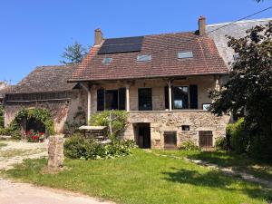 an old stone house with solar panels on the roof at Le Meix Saint Vital in Barizey