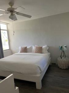 a bedroom with a white bed with a ceiling fan at Condominio Marina Vallarta in Puerto Vallarta +14 photos