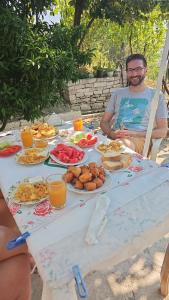 a man sitting at a table with food on it at Isaraj Guest House in Gjirokastër +21 photos
