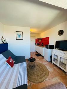 ein Wohnzimmer mit Couch und Küche in der Unterkunft Capstay studio Barcarès in Le Barcarès