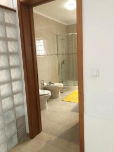 ein Badezimmer mit zwei Toiletten und einem Waschbecken und einer Dusche in der Unterkunft Casa da Fajã in Ponta Delgada + 20 Fotos