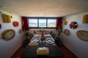ein Esszimmer mit einem langen Tisch und einem großen Fenster in der Unterkunft Dar Sekka in Tangier