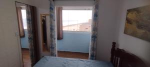 a bedroom with a window and a bed in a room at Apartamento do Simão in Praia Grande