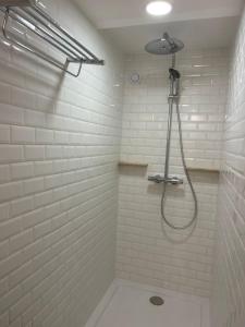 a bathroom with a shower in a white wall at Les Iris in Fontenay-près-Vézelay