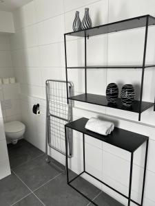 łazienka z czarnymi półkami i toaletą w obiekcie 2 bedroom apartment on ground floor in Blankenberge Vrijheidstraat 3 w mieście Blankenberge