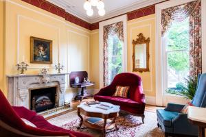 a living room with two chairs and a fireplace at DuPont Mansion Bed & Breakfast in Louisville