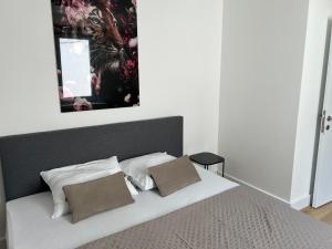 łóżko z 2 poduszkami i lustrem nad nim w obiekcie 2 bedroom apartment on ground floor in Blankenberge Vrijheidstraat 3 w mieście Blankenberge