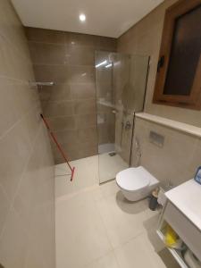a bathroom with a toilet and a glass shower at Modern reviera in Salalah