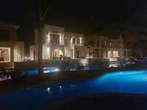 a large house at night with a swimming pool at Modern reviera in Salalah