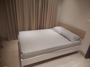 a small bed in a bedroom with curtains at Modern reviera in Salalah