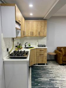 a kitchen with wooden cabinets and a stove top oven at Ozn Suit Airport Hotel in Arnavutköy