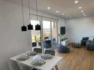 ein Wohnzimmer mit einem weißen Tisch und Stühlen in der Unterkunft Little Penthouse in Waldbüttelbrunn