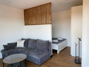ein Wohnzimmer mit einer Couch und einem Tisch in der Unterkunft Little Penthouse in Waldbüttelbrunn