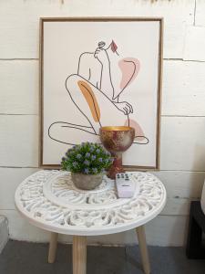 a table with a plant and a picture on a wall at Hostel Los Pargos in Río Sequito