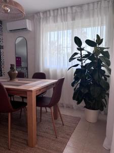 a dining room table with chairs and a plant at Playa de Miramar - 3 Min Walk to the Beach, Family-Friendly, Near Gandia in Miramar